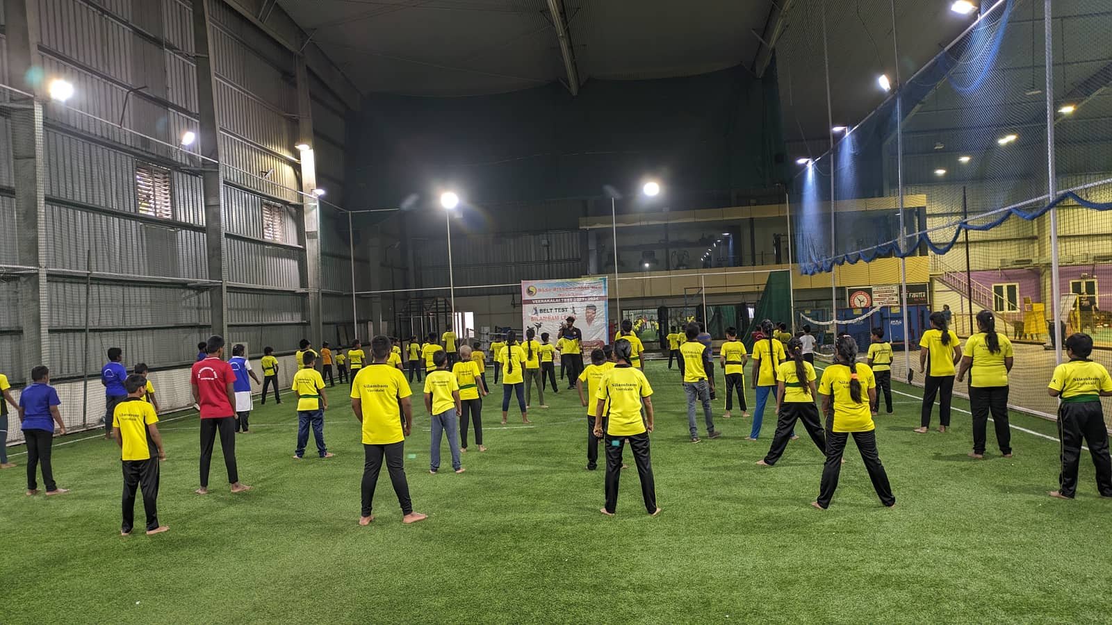 Around sixty students spaced out across the indoor turf for a silambam belt test