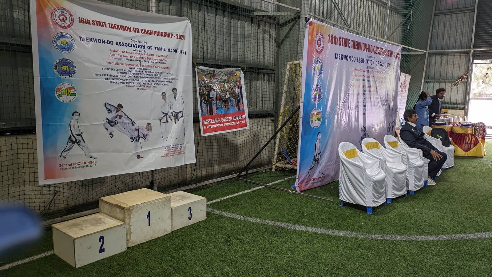 Winners' podium and championship banners set up on the indoor turf at 5rings